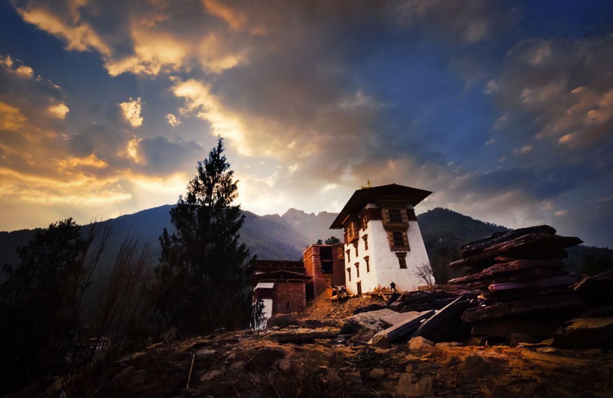 A traditional Bhutanese farmhouse at sunset
