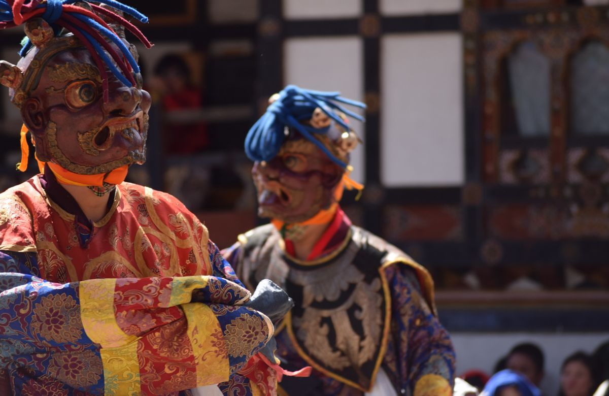 Close view of masked cham dancers at a Bhutanese festival