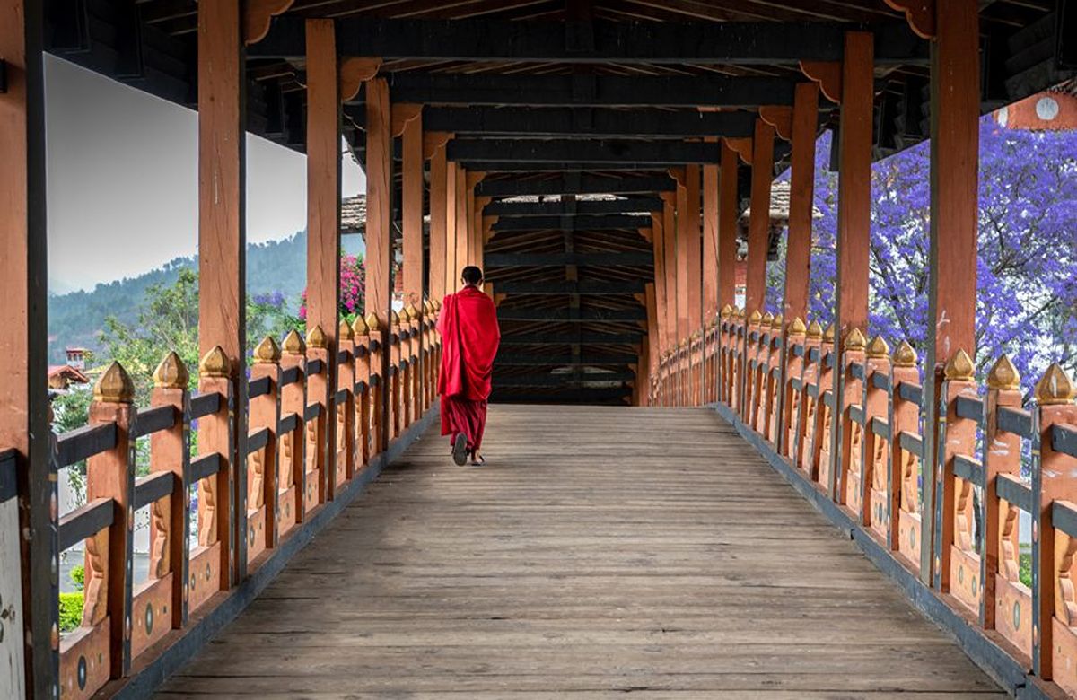 A monk crossing the covered bridge at Punakha Dzong