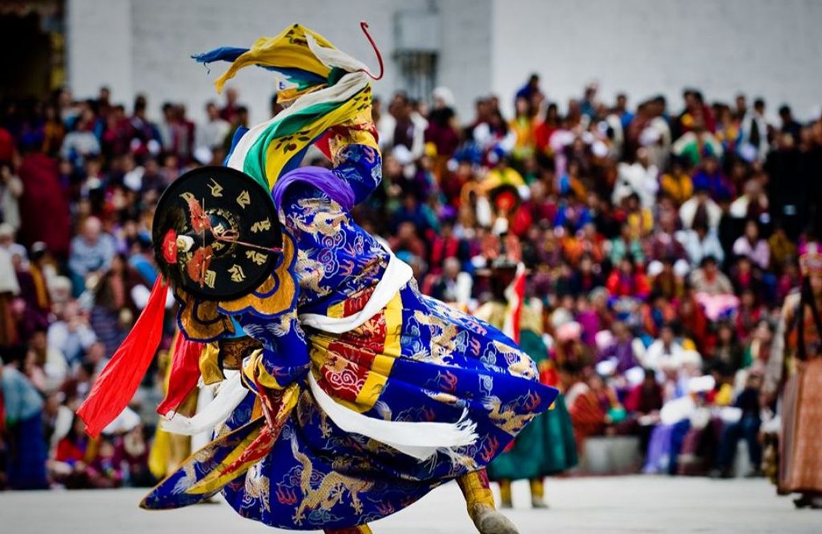 A cham dancer in silk brocade at a Bhutanese tshechu